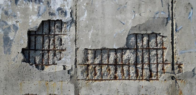 Spalled concrete with exposed corroded reinforcement 
